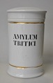 Apotekerkrukke 
i porcelain. 
19. årh. Hvidt 
porcelain med 
to forgyldte 
borter. Sort 
tekst "AMYLUM 
...
