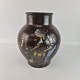 Brun keramik 
vase med motiv 
af en kvinde 
ved en mølle. 
Nr 3600/2
Producent 
Michael 
Andersen ...