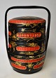 Kinesisk mad 
container i 
fletarbejde, 
20. årh. Rød og 
sortbemalet. 
Med forgyldte 
dekorationer af 
...