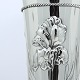 Høj sølvvase i 
tidlig dansk 
skønvirke stil, 
prydet med 
blomster og 
snoet 
sølvkrans. 
H. 25 ...