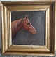 Indrammet 
oliemaleri på 
lærred. Portræt 
af hest i 1932. 
I god stand. 
Mål: 27 x 27 
cm.
