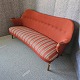 2 personers 
sofa fra 
1960'erne med 
rødt betræk på 
ryglænet og 
stribet betræk 
på sædet. Arme 
...