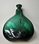 Persisk flaske, 
18. årh. 
Mørkegrønt glas 
med pålagt tråd 
om halsen samt 
kraftig 
halsrand. H. 25 
cm. 