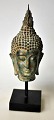 Buddha bust in 
bronze, 20th 
century. On 
wooden base. 
H.: 14 cm. On 
base: 20 cm.