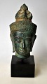 Buddha bust in 
bronze, 20th 
century. On 
wooden base. 
H.: 13 cm. On 
base: 19 cm.
