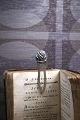 Old bookmark in silver (Stamped) with flower at the top.