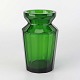 Lille vase i 
mundblæst grønt 
glas med 
facetslebet 
kantede sider 
og rund 
topkant.
Producent ...