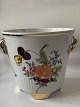 Urtepotteskjuler 
med 
blomstermotiv / 
4 fødder.
Diameter 
indvendige mål 
15 cm. 
Højde 14,5 ...