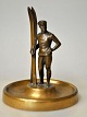 Tysk kunstner 
(20. årh.): En 
skiløber med 
sine ski. 
Bronzefigur. 
Usigneret. 
Figurn står på 
en ...