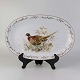 Ovalt 
serveringsfad i 
porcelæn med 
motiv af fasan 
fra stellet 
Jagtstel. Nr. 
35
Formgiver Mads 
...