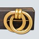 Broche af 18 
kt. guld. En 
cirkel med glat 
overflade, den 
anden med 
riller.
L. 3,4 cm. H. 
2,9 ...