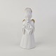 Figur med motiv 
af en engel som 
spiller på 
valdhorn. 
Figuren er i 
hvidt porcelæn 
med forgyldte 
...