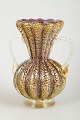 Murano
Vase med 
hanke, 
1960’erne.
Dekorativ 
Murano-vase med 
riflede sider, 
to klare 
håndtag og ...