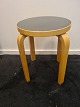 Taburet designet af Alvar Aalto. Her i bøg med sæde i sort formika. Fremstår pæn og velholdt ...