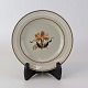Desserttallerken i fajance fra stellet Kirsten, som blev fremstillet i perioden 1934-1957. ...