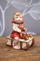Royal Copenhagen Pixie nisse i porcelæn , nr.764.Pige på kælk med lille bamse. Højde: 6cm. ...