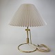 Bordlampe i messing med hvid plisseret skærm. Lampen kan også bruges som væglampeDesign ...