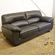 Overpolstret 3 personers sofa betrukket med sort læder med ben i mørklakeret træ.Producent ...