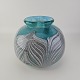 Rund vase i turkisblåt glas og abstrakt fjerlignede dekoration i sort og hvidt med boblet ...
