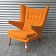 Lænestol med stel og negle i teaktræ betrukket med Hallingdal uldstof nr. 65-547 i orange farve. ...