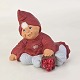 Figur fra serien Klarborg Jul med motiv af den æbleglade nisse Caroline, som sidder med sin ...