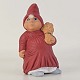 Figur fra serien Klarborg Jul med motiv af den sang-glade nisse Sofie, som står med et fugleneg. ...