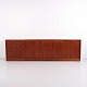 Lang og lav skænk udført i teak fra 1960'erne i mid-century modern stil. Skænken har et enkelt ...