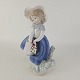 Figur af porcelæn med motiv af en pige i blå kjole, som holder en kurv med blomster. Nr ...