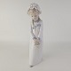 Figur af porcelæn med motiv af en pige med fletninger og lang kjole.Producent ...