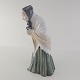 Figur i kongelig porcelæn, med motiv af en foroverbøjet kvinde med tørklæde på og en bog i ...