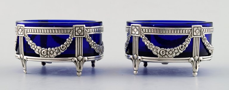 A pair of English salt vessels with glass inserts in English silver.
