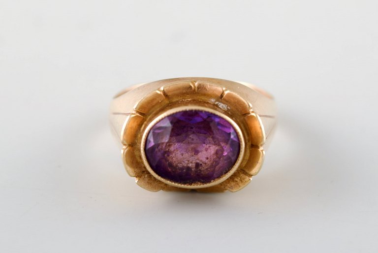 Danish goldsmith. 14 carat art deco gold ring adorned with purple stone.