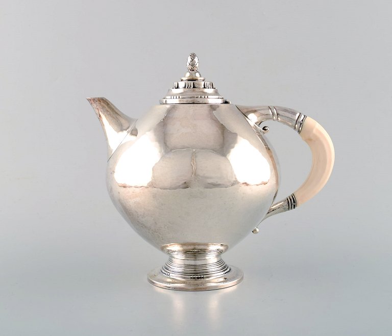 Johan Rohde for Georg Jensen. Rare and early teapot in sterling silver. Round 
body and ivory handle. Dated 1919.