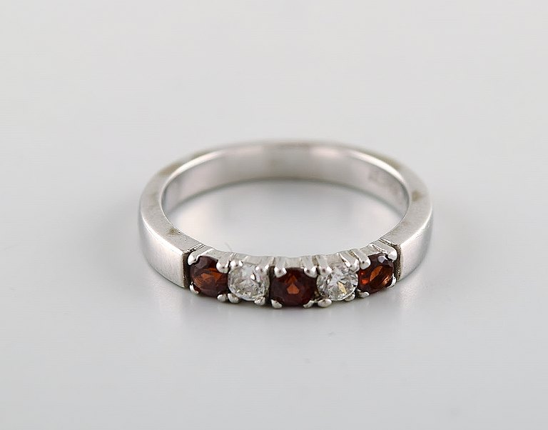 Chanti. Alliance ring in 8 carat white gold adorned with brilliants and semi 
precious stones. Late 20th century.