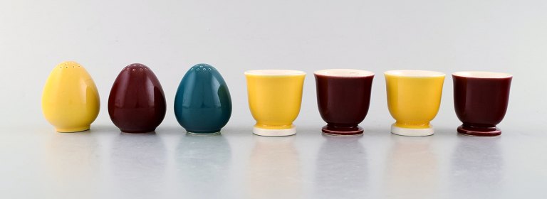 Confetti Royal Copenhagen / Aluminum faience. Three salt shakers and four egg 
cups in glazed faience. Bordeaux, yellow and turquoise glaze.
