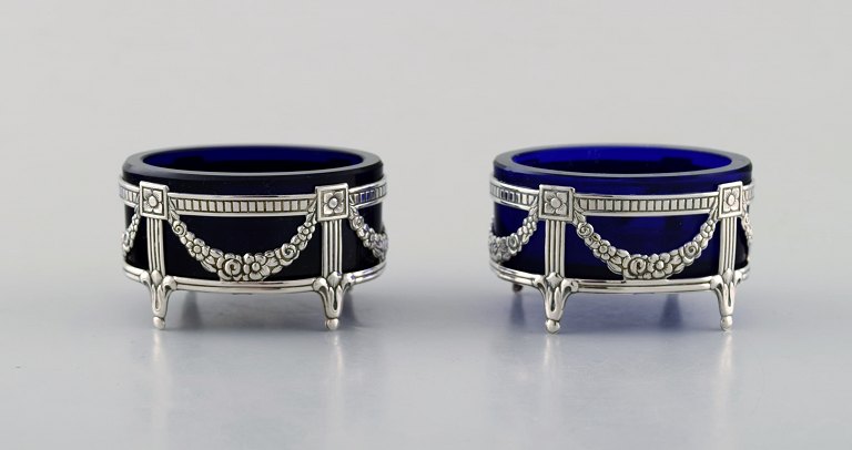 Swedish silversmith. Two silver salt vessels in empire style with royal blue 
glass inserts.