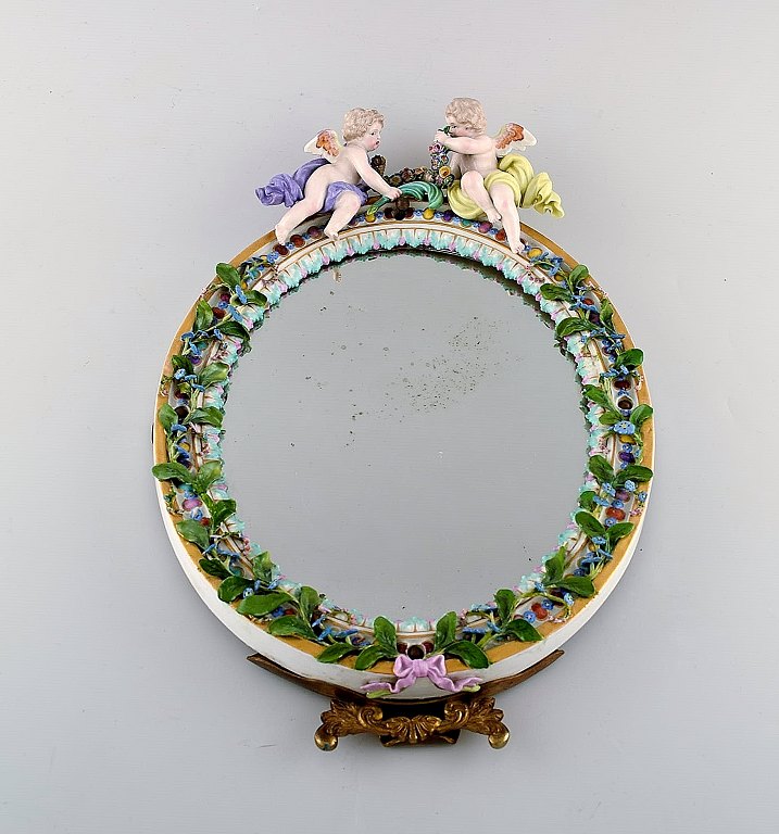 Meissen porcelain mirror. Decorated with angels and repousse flowers. Ca. 1900.