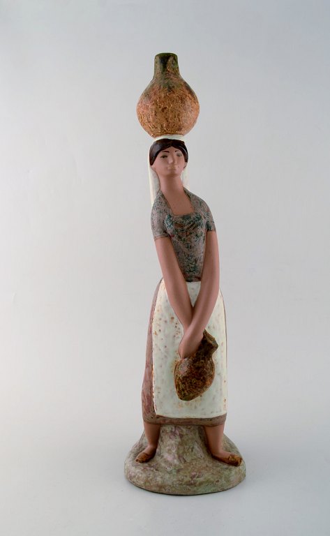 Lladro, Spain. Large figure in glazed ceramics. Woman carrying water. Late 20th 
century.
