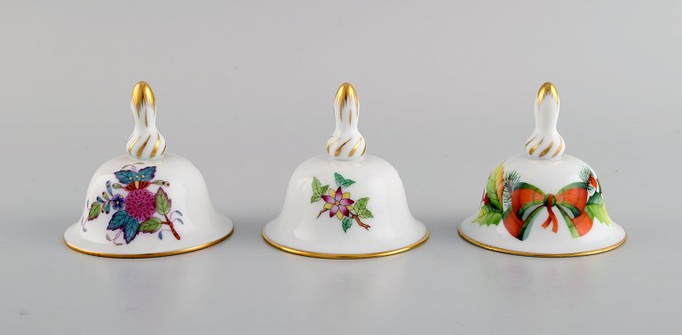 Tre Herend bordklokker i håndmalet porcelæn med blomster og gulddekoration. 
1980