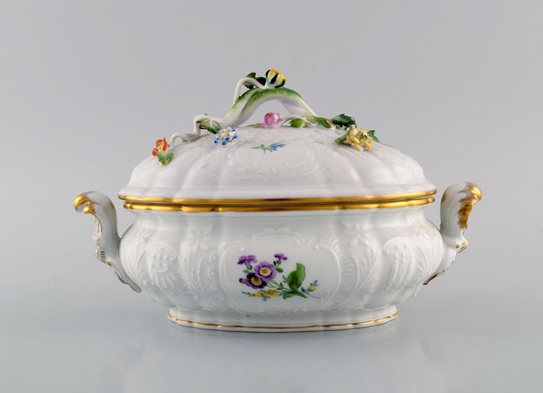 Meissen porcelain lidded tureen with hand-painted flowers and gold edge. Lid 
modeled with flowers and foliage. 1920s.
