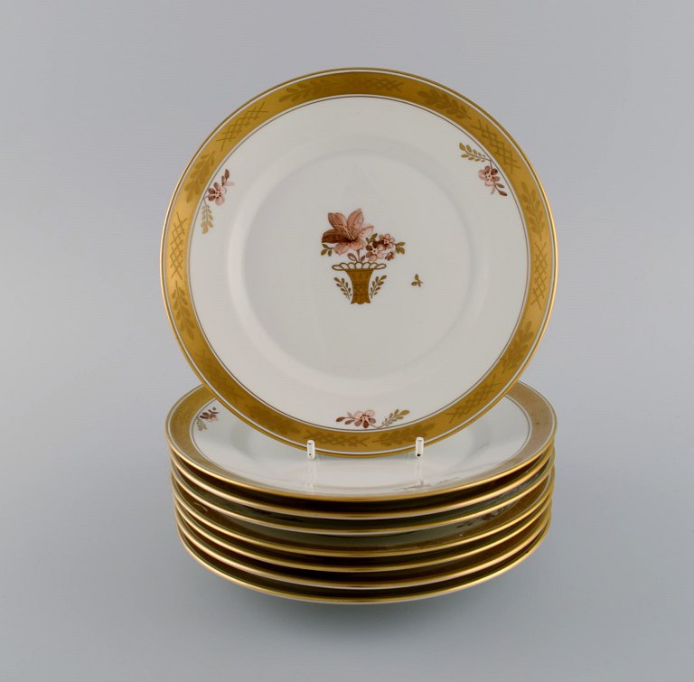 Otte Royal Copenhagen Guldkurv frokosttallerkener i håndmalet porcelæn med 
blomster og gulddekoration. 1960