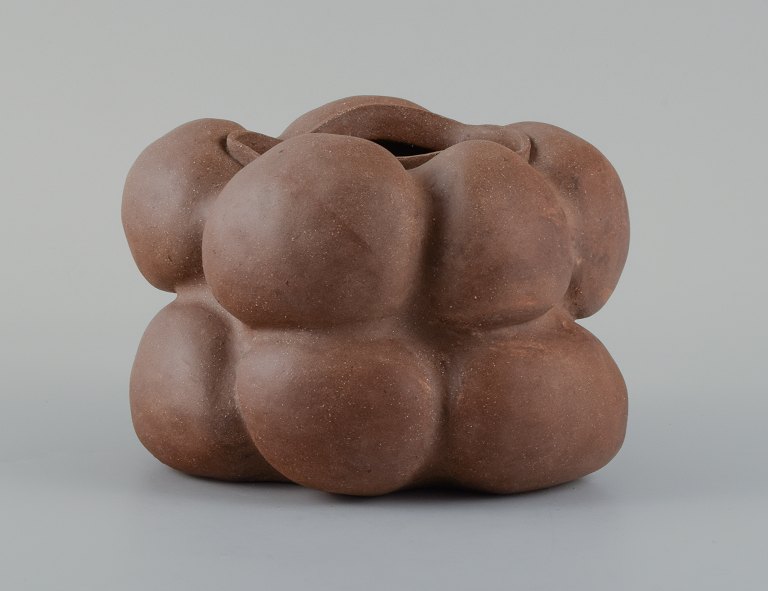 Christina Muff, dansk samtidskeramiker (f. 1971).
Dark brown unglazed vessel. Organic shaped vase with lips. Clear glaze inside.