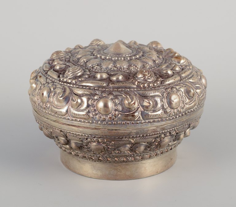 Chinese silversmith. Lidded jar richly decorated in relief with flowers and 
ornaments.