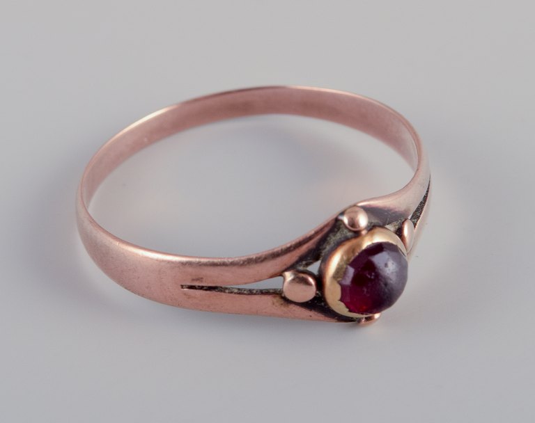 C. T. Haagensen, Rønne, aktiv 1893-1937.
Ældre 14 karat Art Deco rødguldring.
Prydet med bordeauxfarvet halvædelsten.